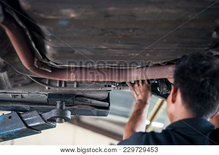 Auto Mechanic Asian Checking Bush-bolt Under Double Wishbone Suspension By Hand With Tools Car Lift