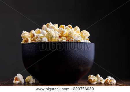 Popcorn In A Ceramic Bowl On A Wooden Background.