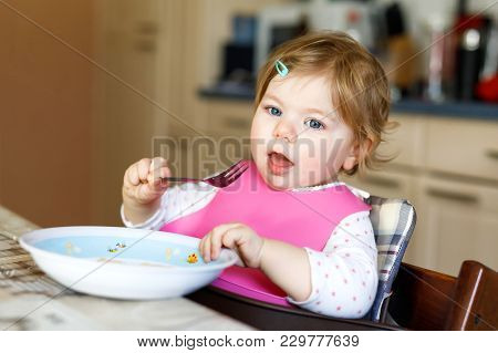 Adorable Baby Girl Eating From Spoon Mashed Vegetables And Puree. Food, Child, Feeding And Developme