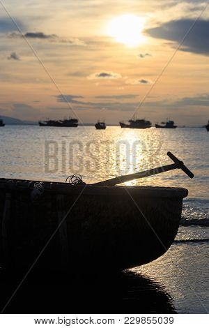 Closeup Vietnamese Fishing Boat Silhouettes In Sea At Sunset Against Bright Sunlight Reflection