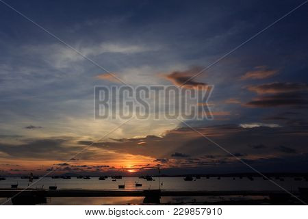 Closeup Vietnamese Fishing Boat Silhouettes In Sea At Sunset Against Bright Sunlight Reflection