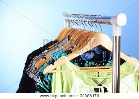เสื้อผ้าต่าง ๆ บนไม้ hangers บนพื้นหลังสีน้ำเงิน