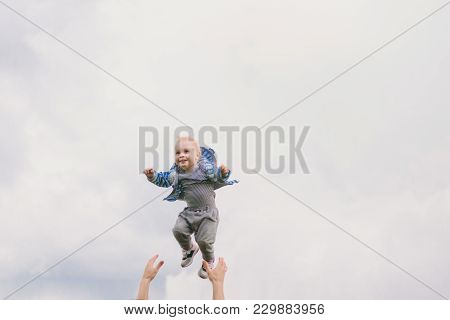 Man Hands High Toss Up Little Cute Child Baby Boy On Blue Clouds Sky Background. Father Rest, Have F