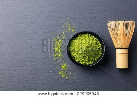 Matcha, Green Tea Powder In Black Bowl With Bamboo Whisk On Slate Background. Top View. Copy Space.