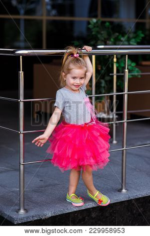 Little Girl Child Wearing A Pink Skirt Outdoors Having Fun
