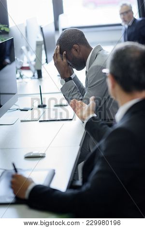 Selective Focus Of Stressed African American Businessman And Arguing Colleague In Office