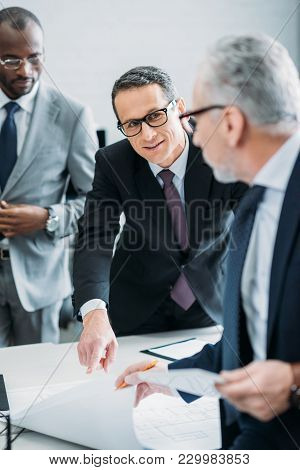 Selective Focus Of Multicultural Businessman Discussing New Strategy In Office