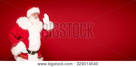Real Santa Claus On Red Studio Background.