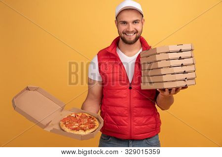 Cheerful Pizza Delivery Man Stands With Carton Boxes, Waits For Client, Wears White Cap And White T 