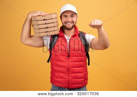 Cheerful Pizza Delivery Man Stands With Carton Boxes, Waits For Client, Wears White Cap And White Ts