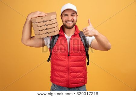 Cheerful Pizza Delivery Man Stands With Carton Boxes, Waits For Client, Wears White Cap And White Ts