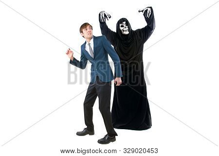 Man In A Halloween Grim Reaper Ghost Costume Chasing, Mocking And Making Fun Of Scared Businessman R