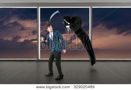 Man In A Halloween Grim Reaper Ghost Costume Chasing, Mocking And Making Fun Of Scared Businessman R