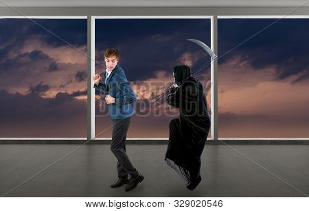 Man In A Halloween Grim Reaper Ghost Costume Chasing, Mocking And Making Fun Of Scared Businessman R