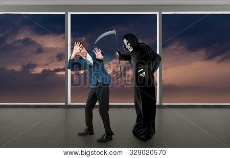 Man In A Halloween Grim Reaper Ghost Costume Chasing, Mocking And Making Fun Of Scared Businessman R