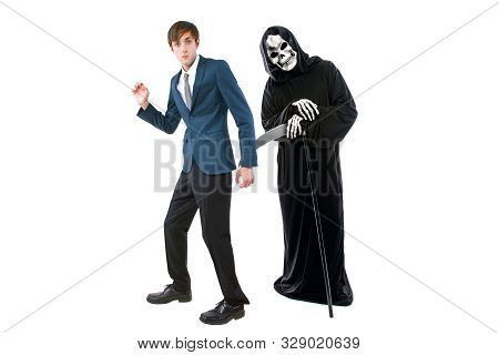 Man In A Halloween Grim Reaper Ghost Costume Chasing, Mocking And Making Fun Of Scared Businessman R