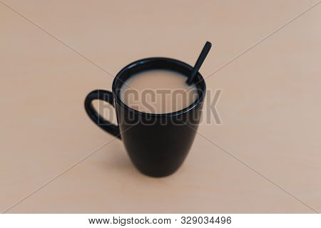 Chai Tea With Milk In Black Mug On Wooden Table Of The Same Color Shot From 45 Degrees Angle