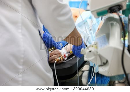 Doctor Preparing Patient For Surgery In Operating Room, Closeup
