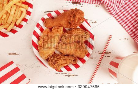 Perfect fried chicken pieces fast food on red white striped plate