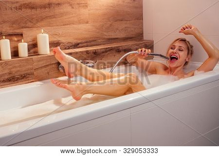 Young Blonde Emotional Woman Relaxing In Bath With Foam Singing Loud