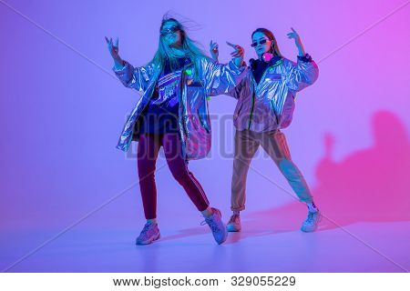 Young Stylish Girls Dancing In The Studio On A Colored Neon Background. Music Dj Poster Design.