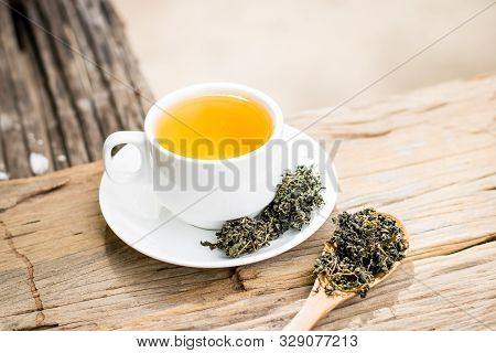 Dry Gynostemma Pentaphyllum Leaf With Brewed Tea In A White Cup On The Wood Floor