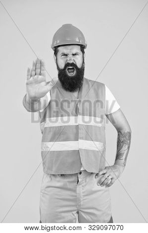 Stop, Mining Area Under Construction. Mining Engineer Showing Caution Sign On Yellow Background. Con