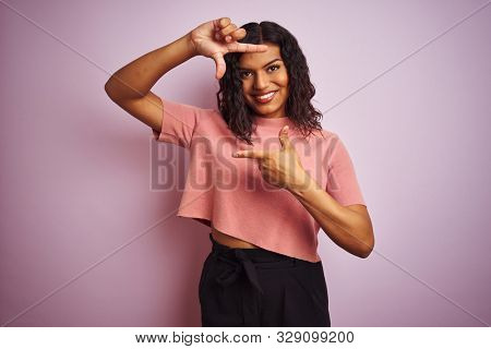 Young beautiful transsexual transgender elegant woman over isolated pink background smiling making frame with hands and fingers with happy face. Creativity and photography concept.