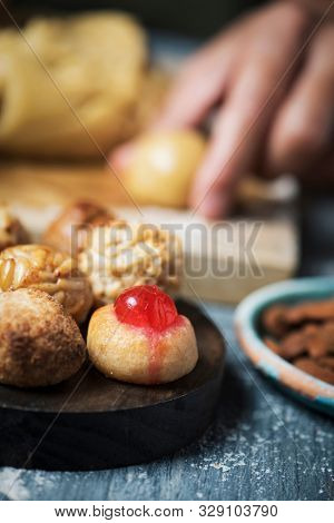 closeup of a young caucasian man preparing some panellets, sweet food typically eaten in All Saints Day in Catalonia, Spain