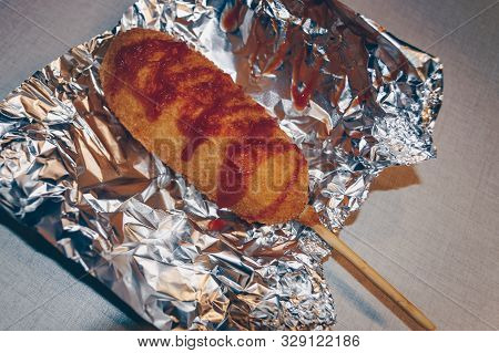 Freshly Made Hot Corn Dog Inside Of Foil To Preserve Heat