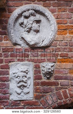 Gdansk, Poland - August 23, 2019: Reliefs On Bricky Wall Inside Yard Of Medieval Prison Tower And To