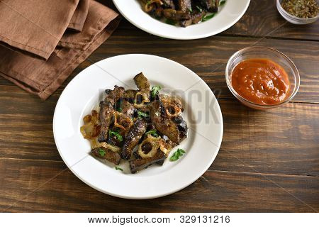 Fried Beef Liver With Onion On Plate Over Wooden Background. Pieces Cooked Liver (offal) From Beef.