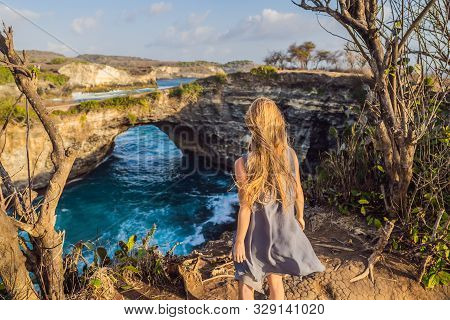 Young Woman Tourist Near Broken Beach In Nusa Penida, Indonesia Angels Billabong Beach. Popular Tour