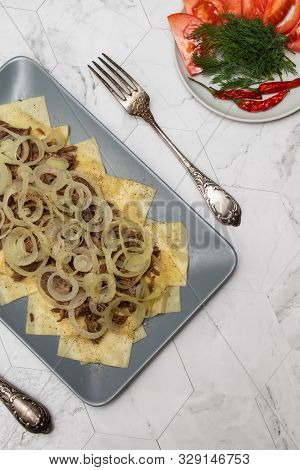 Beshbarmak Is A National Tatar Dish - Square Pasta With Boiled Meat And Onions. On A Light Backgroun