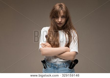 A Young Beautiful Girl With Long Wavy Rustic Hair, Nud Makeup, In A White Jersey, Stands Crossing He
