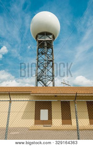 Weather Radar Tower Against Blue Sky With Clouds.