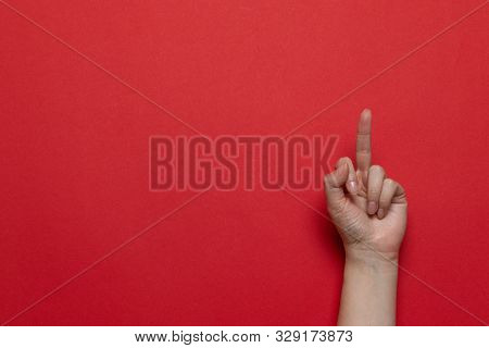 Woman Hand Showing Middle Finger On A Red Background. Flat Lay Style Composition, Top View.