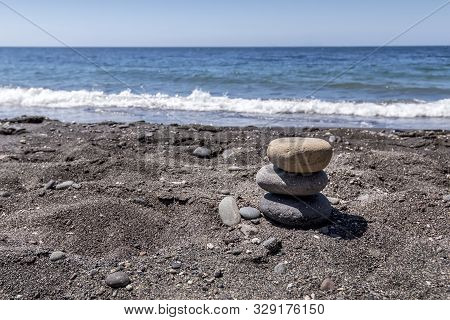 Sea Surf On The Beach With Black Volkanic Sand And Stones.
