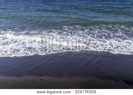 Sea Surf On The Beach With Black Volkanic Sand.