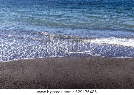 Sea Surf On The Beach With Black Volkanic Sand.
