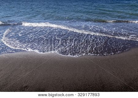 Sea Surf On The Beach With Black Volkanic Sand.