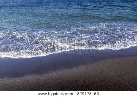 Sea Surf On The Beach With Black Volkanic Sand.
