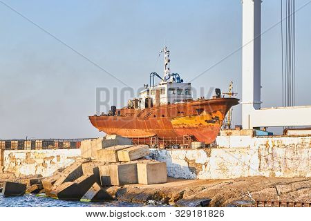 Old Rusty Abandoned Ship On The Shore For Repair