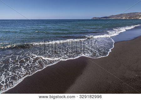 Sea Surf On The Beach With Black Volkanic Sand.