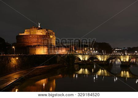 Castel Santangelo And Ponte Saint Angelo Bridge By Night In Rome, Italy