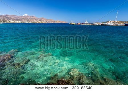 Agios Nikolaos Coastline On A Sunny Day With Clear Sea And Cliffs.