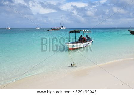 Kendwa, Tanzania - October 3, 2019: Motor Boats With Locals Men Moored On The Kendwa Beach, Zanzibar