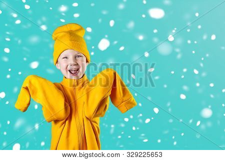 A Cheerful Guy In A Bright Yellow Jacket And Hat Enthusiastically Rejoices On A Mint Background