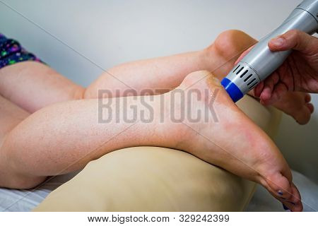 Using Radial Shockwave Therapy Machine On Clients Feet In Beauty Parlor