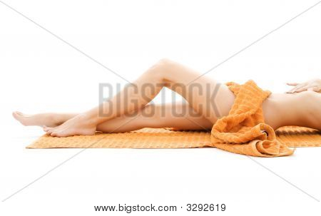 Gambe lunghe di Lady rilassata con asciugamano arancia